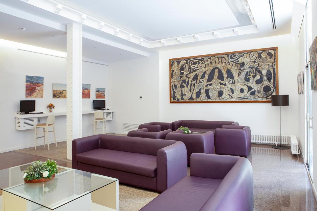 een woonkamer met paarse banken en een tafel bij Gaudi Hotel in Barcelona