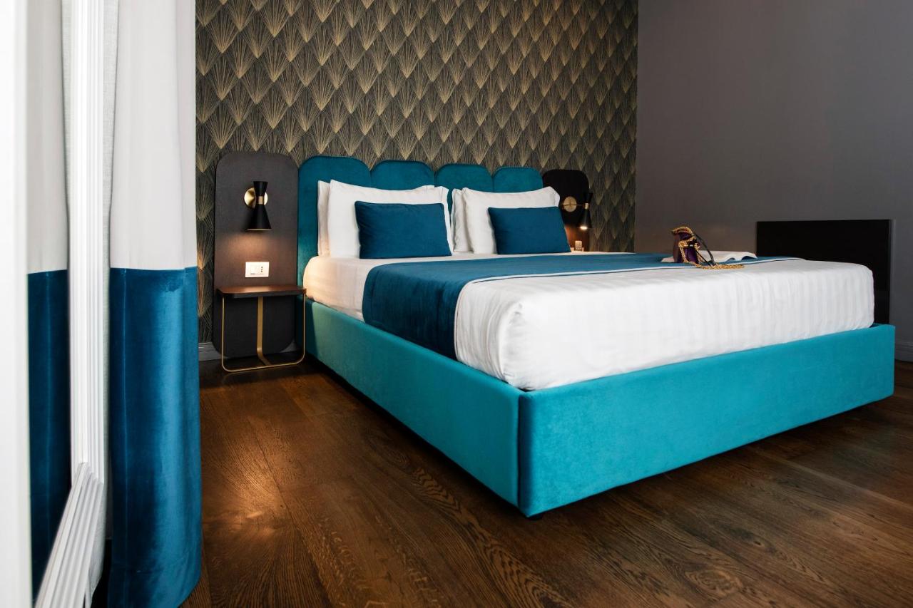 een slaapkamer met een blauw bed en blauw-witte kussens bij Hotel 87 eighty-seven - Maison d'Art Collection in Rome