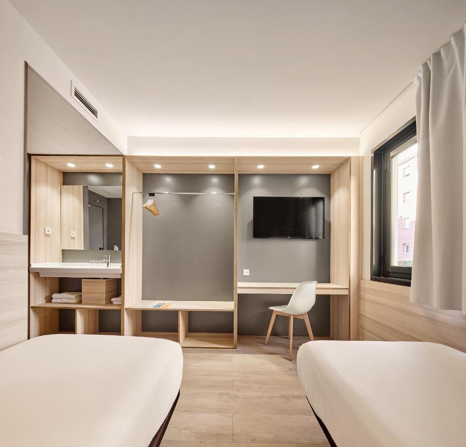 een hotelkamer met twee bedden en een tv bij Hostal Lami in Esplugues de Llobregat