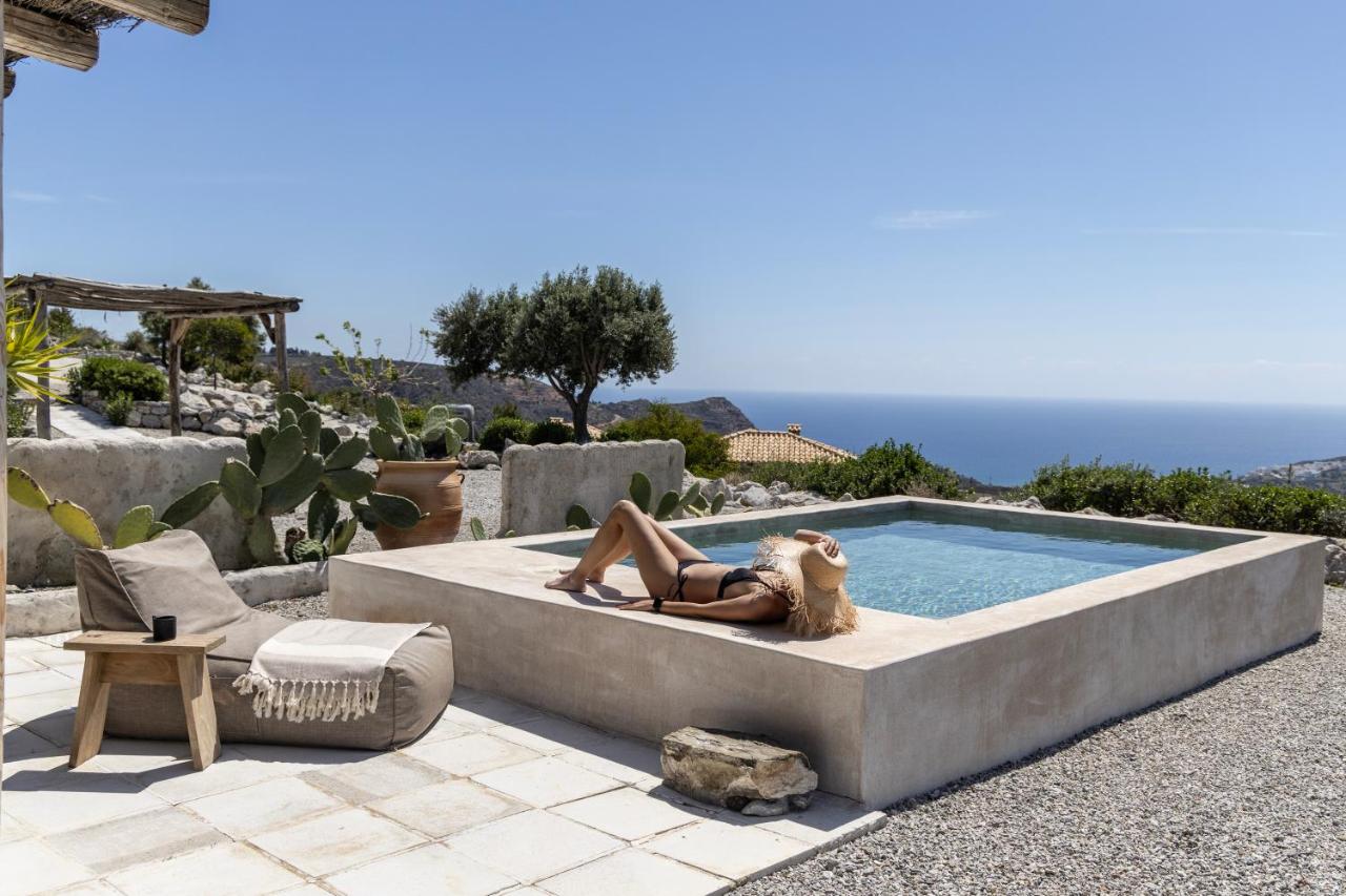 Een vrouw in een bikini ligt naast een zwembad. bij Palazzo Greco Villas in Agia Galini