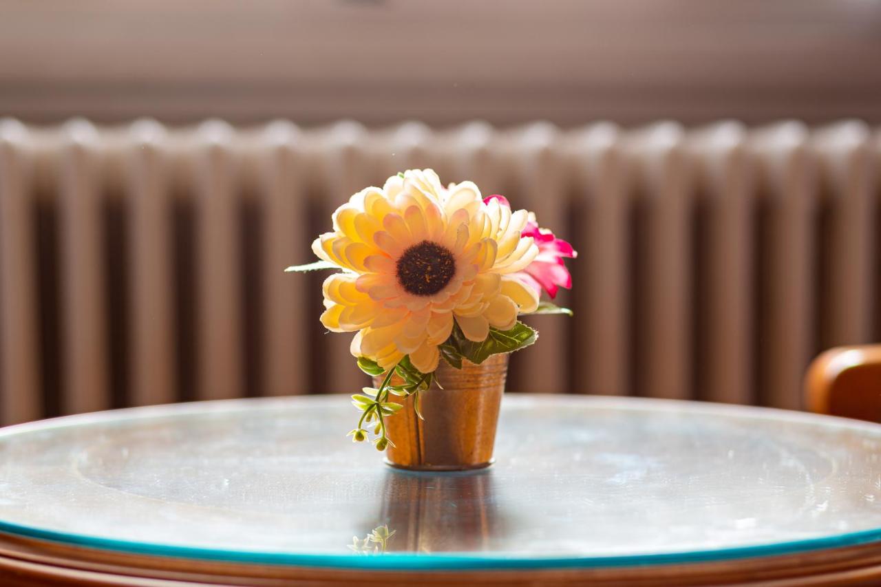 een klein vaasje met een bloem op een tafel bij Hotel Villani in Florence