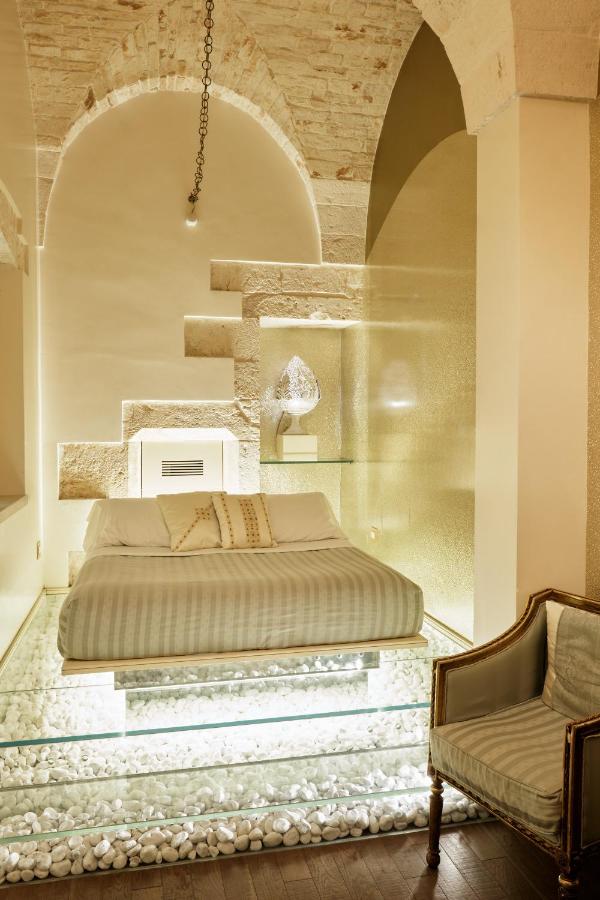 een slaapkamer met een groot bed en een stoel bij Palazzo Scotto in Alberobello