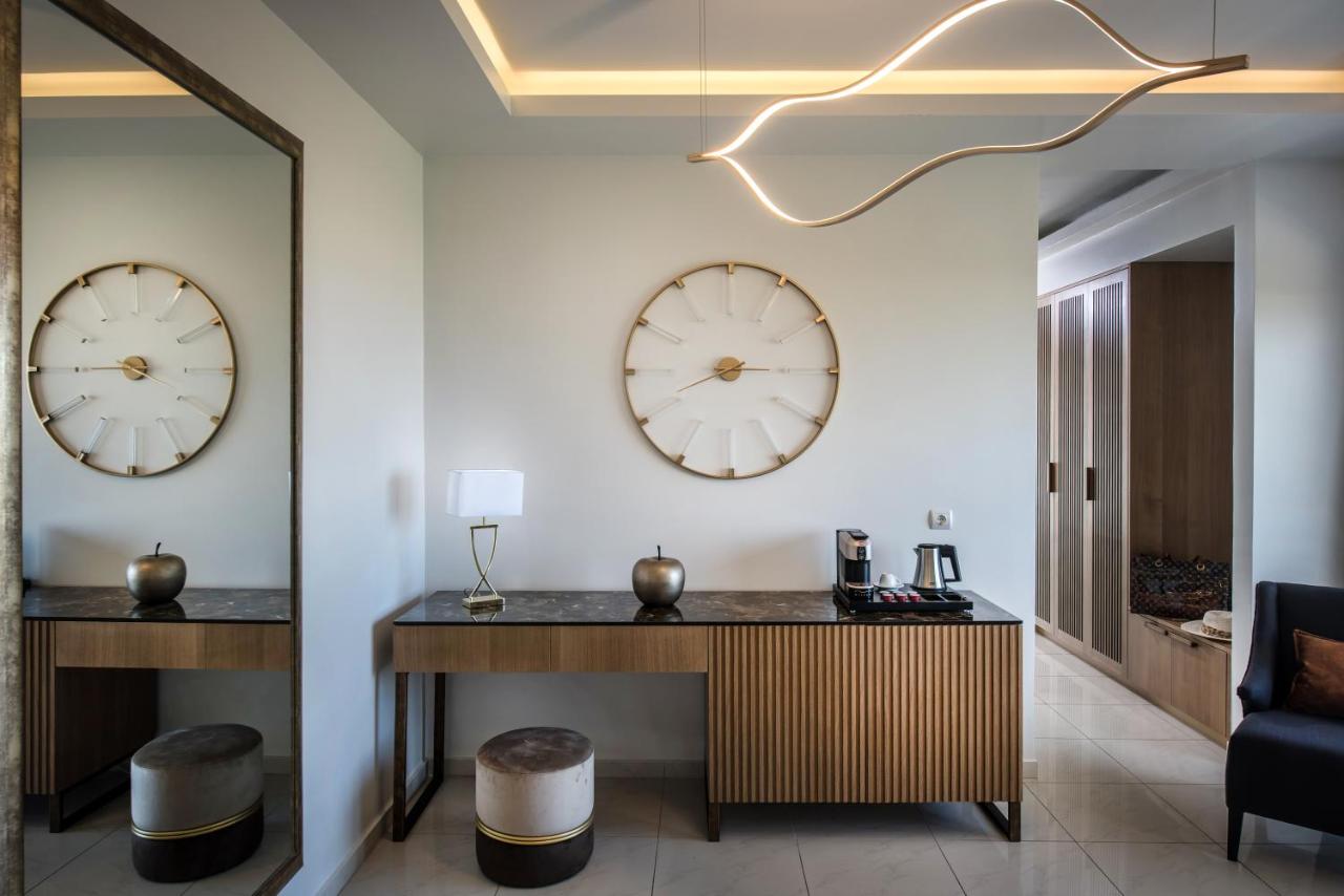 een lobby met twee klokken aan de muur en een bureau bij Hotel Matheo Villas & Suites in Malia