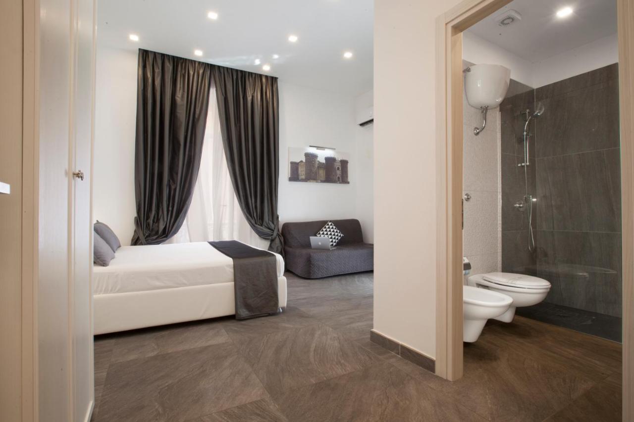 een slaapkamer met een bed, een toilet en een badkamer bij Suite dei Catalani in Napels