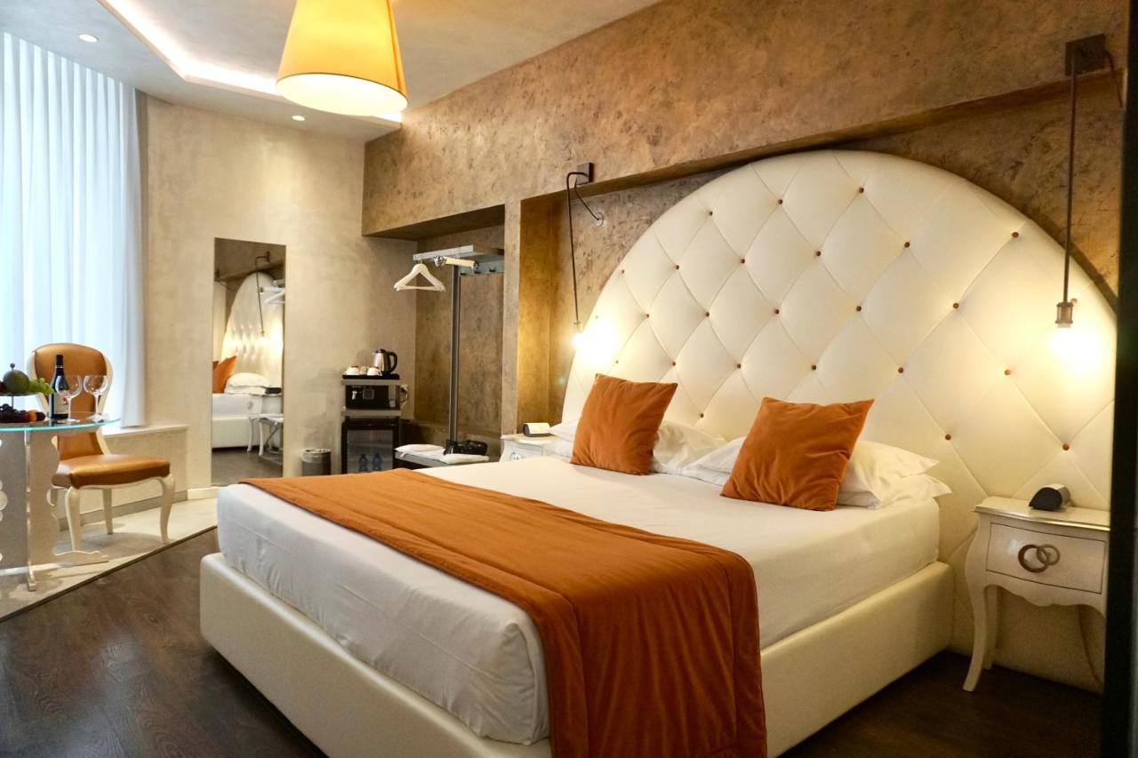 een slaapkamer met een groot bed met een groot hoofdeinde bij Hotel Vespasiano in Rome