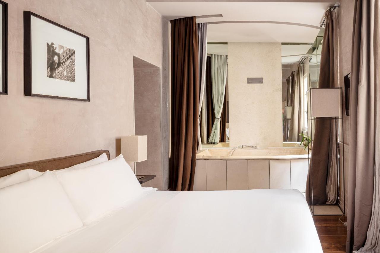 een slaapkamer met een wit bed en een badkamer bij Ricasoli Firenze Luxury Apartments | UNA Esperienze in Florence