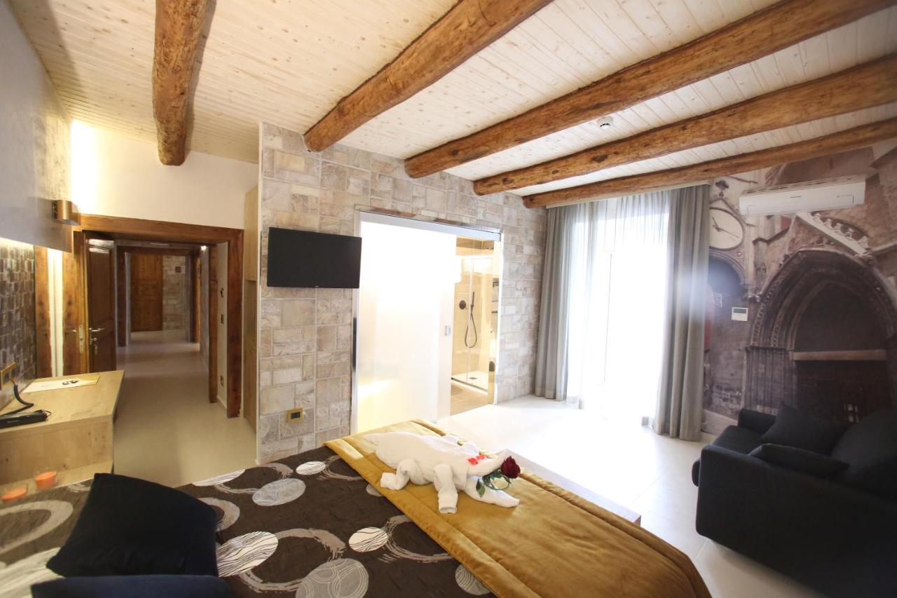 een woonkamer met een bed en een open haard bij Relais Piazza Del Plebiscito B&B in Napels