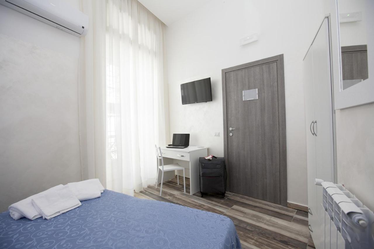een slaapkamer met een bed, een bureau en een deur bij Napoli Garibaldi Square in Napels