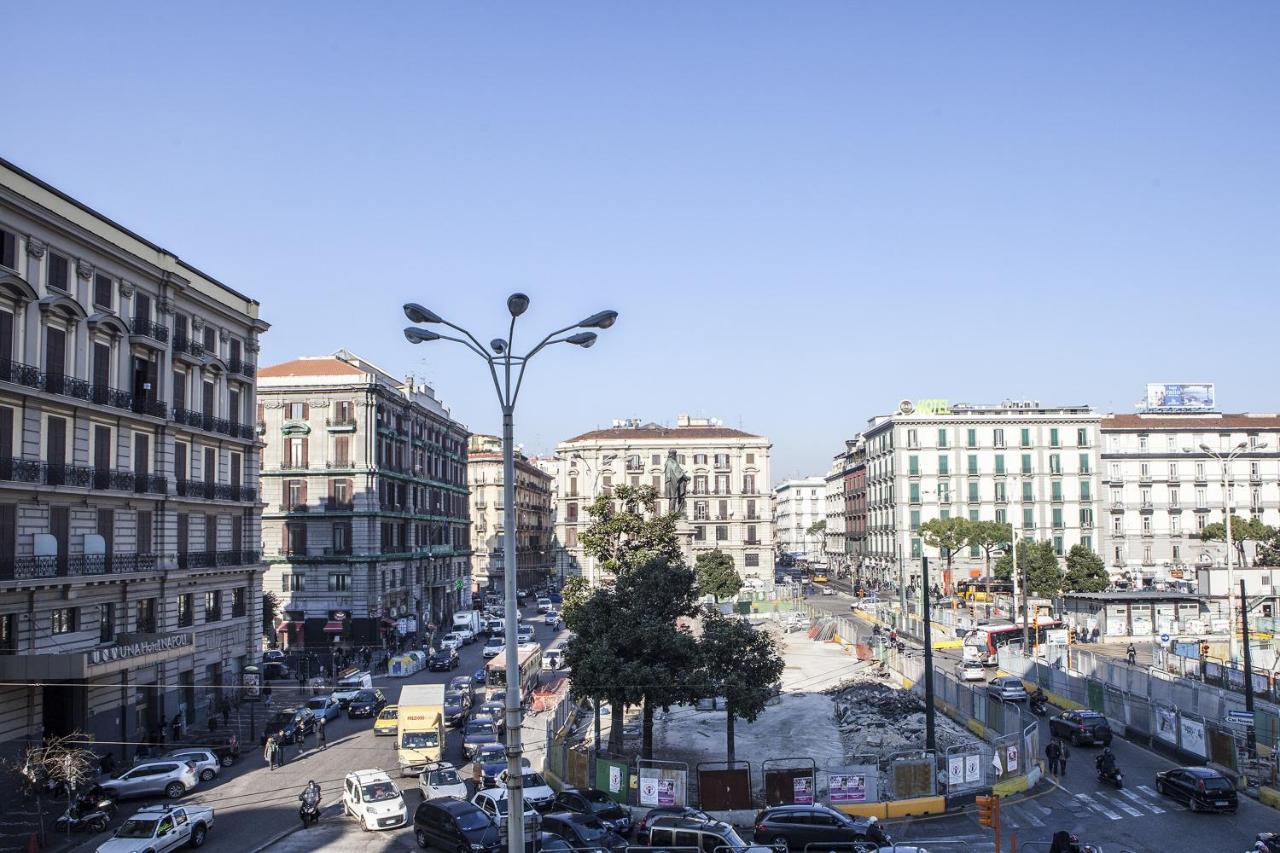 een drukke stadsstraat met auto's en gebouwen bij Napoli Garibaldi Square in Napels