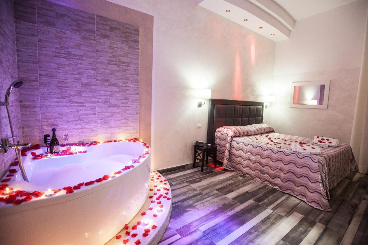 een badkamer met een bad en een slaapkamer met een bed bij Napoli Garibaldi Square in Napels