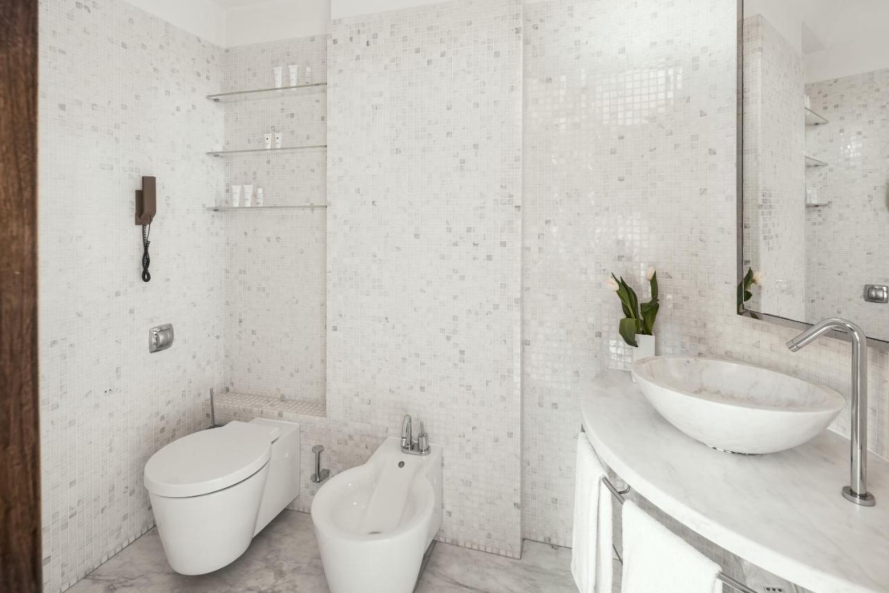 een witte badkamer met een toilet en een wastafel bij Repubblica Firenze Luxury Apartments | UNA Esperienze in Florence