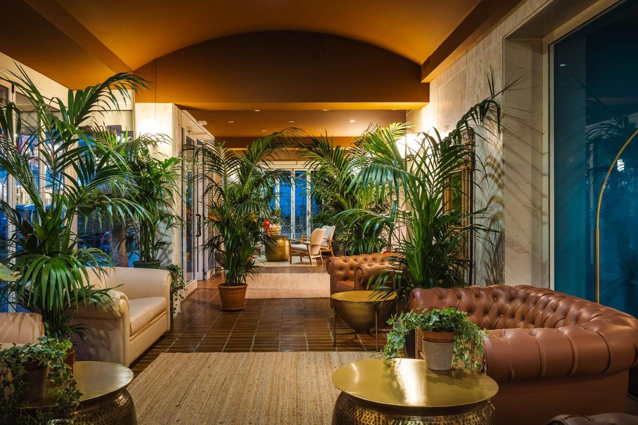 een lobby met leren meubels en potplanten bij Hotel Portofino in Lido di Jesolo