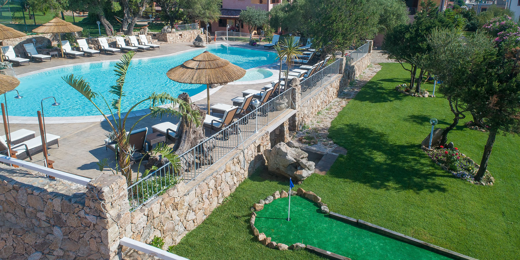 Zwembad omringd door palmbomen — Hotel i Ginepri