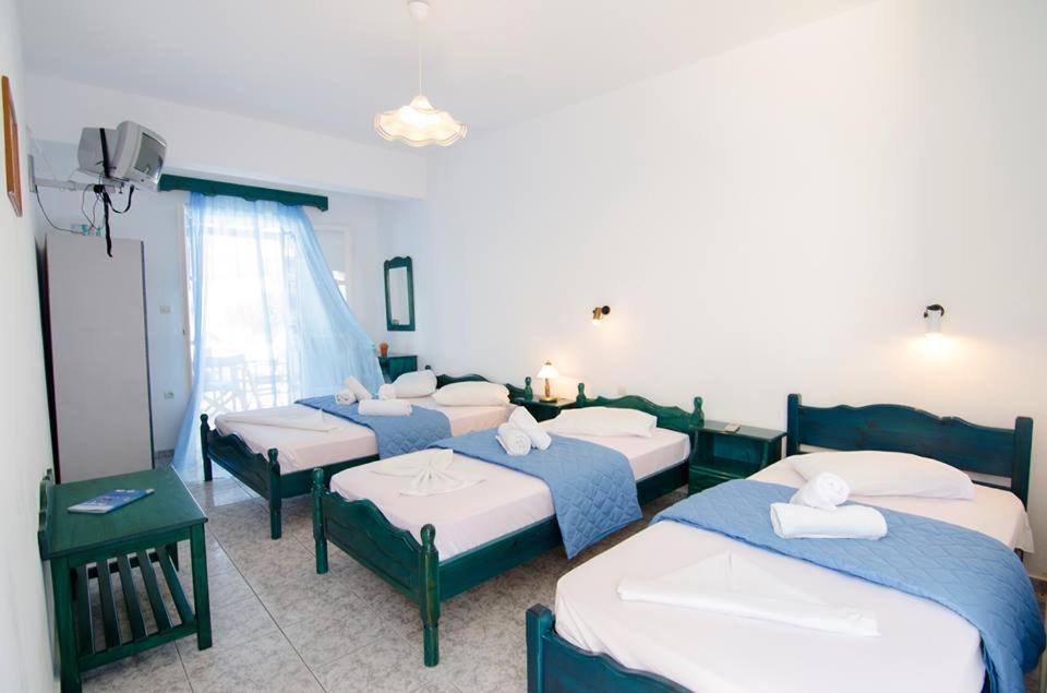 een groep van vier bedden in een kamer bij Pension Christina in Aiyiáli