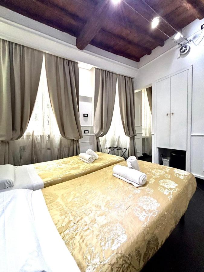 twee bedden in een slaapkamer met gordijnen bij L'antica Locanda Dell'Orso in Rome