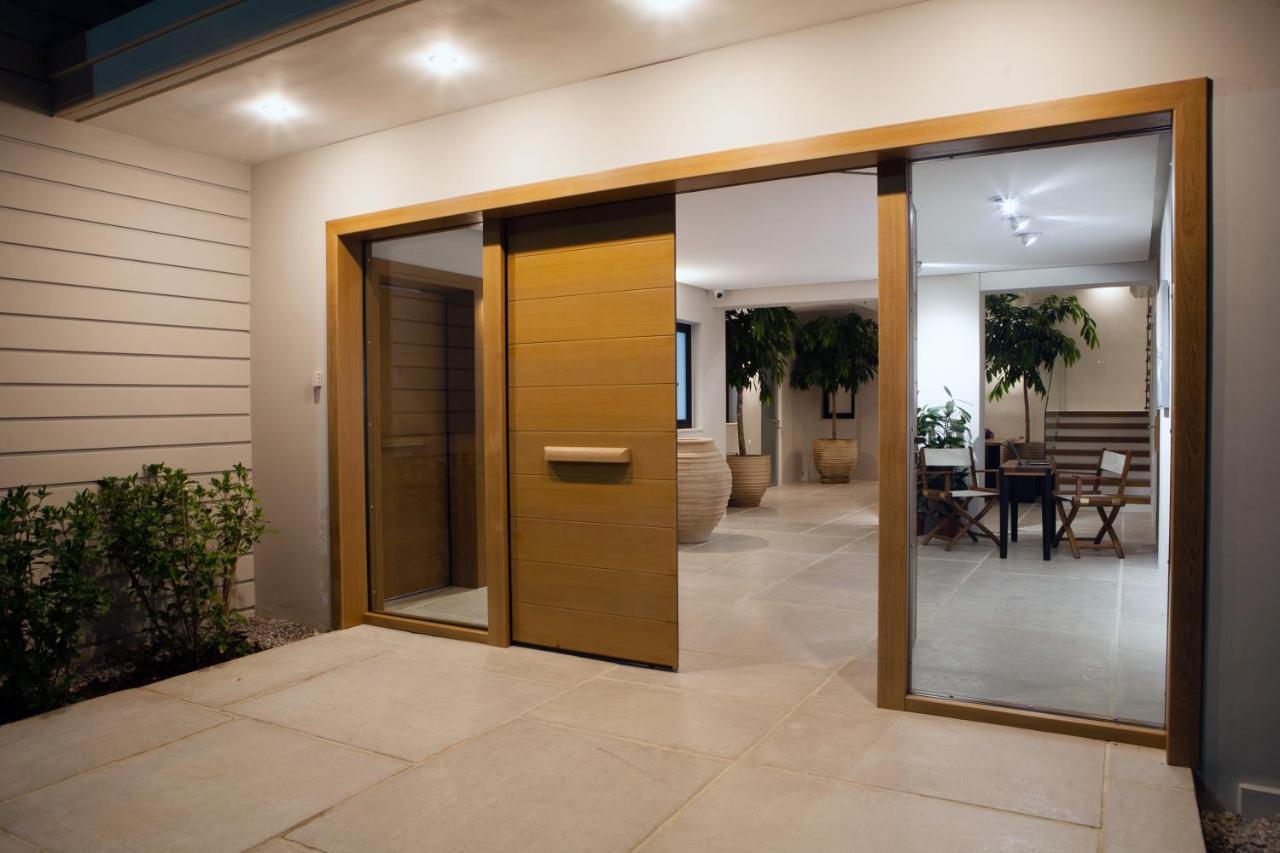 een houten draaideur in een huis met een patio bij Aethrion Boutique Homes in Kato Daratso +9 foto's