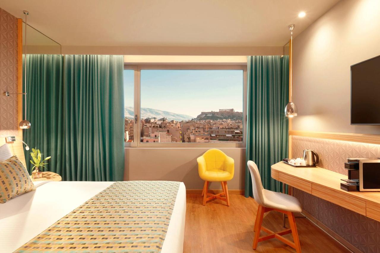 een hotelkamer met een bed en een raam bij Zeus Wyndham Grand Athens in Athene
