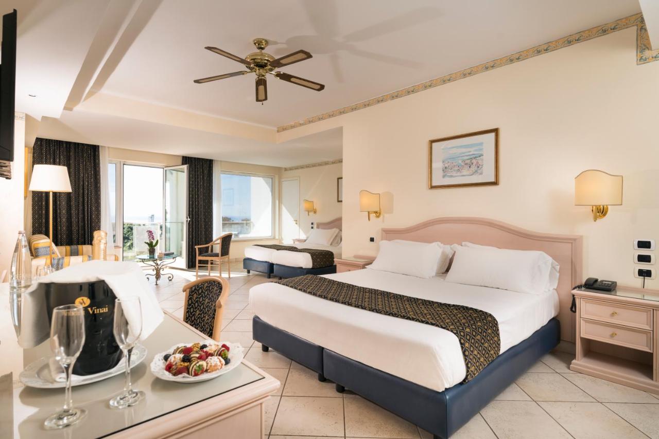 een hotelkamer met een bed en een tafel met een fruitschaal bij Sant Alphio Garden Hotel & SPA in Giardini Naxos