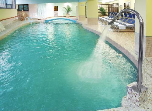 een zwembad met een waterfontein in een hotel bij Sporting Baia Hotel in Giardini Naxos