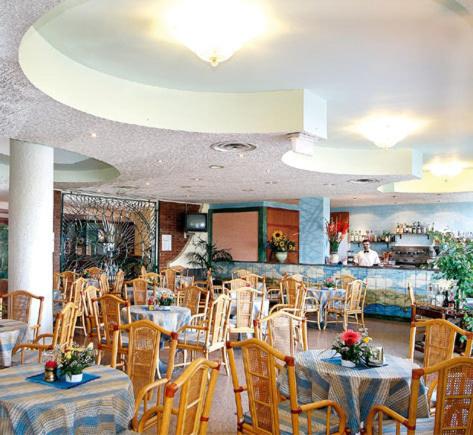 een eetzaal met tafels en stoelen in een restaurant bij Sporting Baia Hotel in Giardini Naxos
