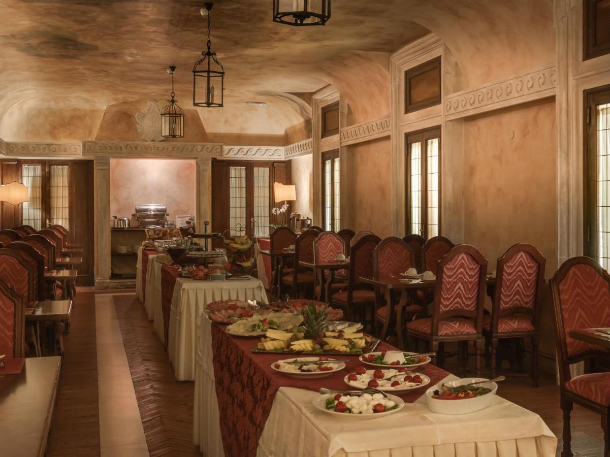 een eetkamer met tafels en stoelen waarop eten staat bij Palazzo Cardinal Cesi in Rome