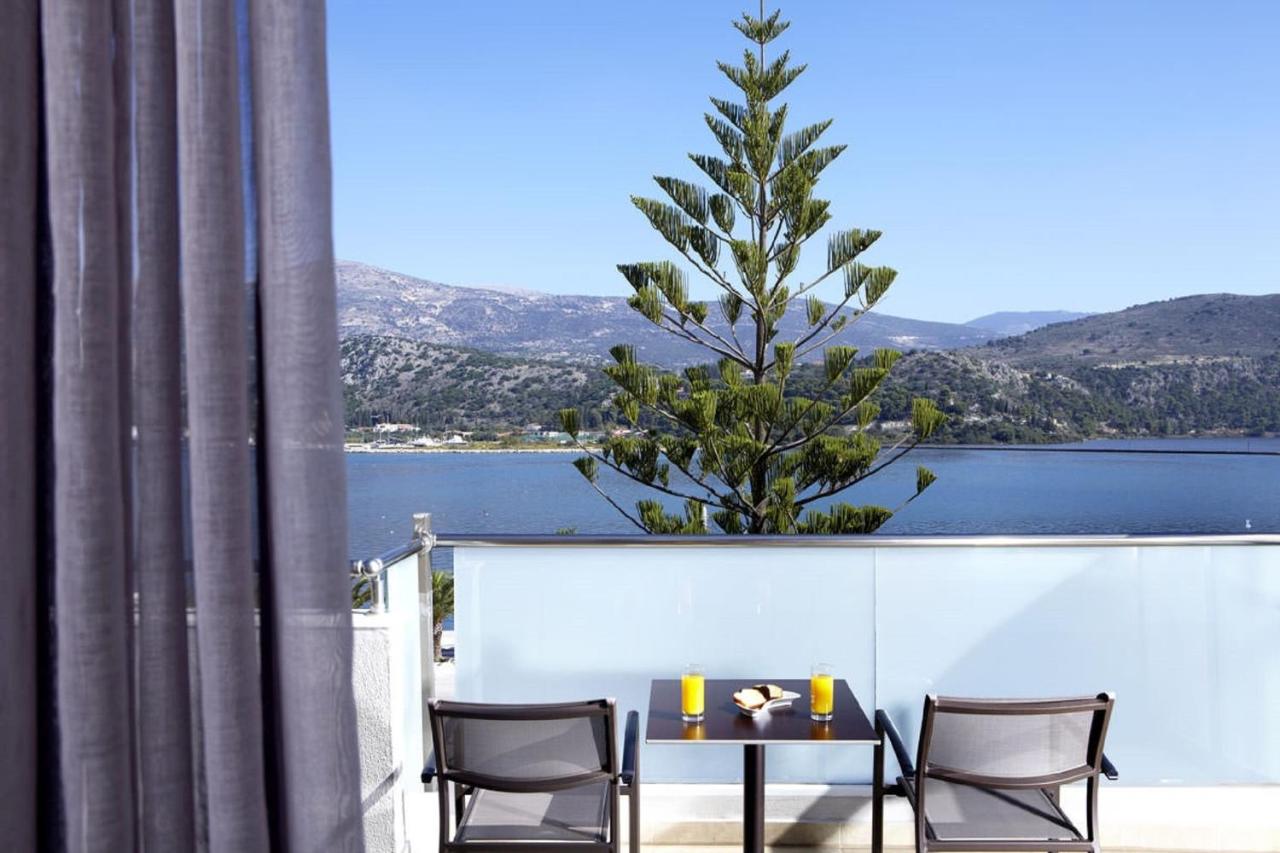 een tafel en stoelen op een balkon met een boom bij Mouikis Hotel Kefalonia in Argostoli