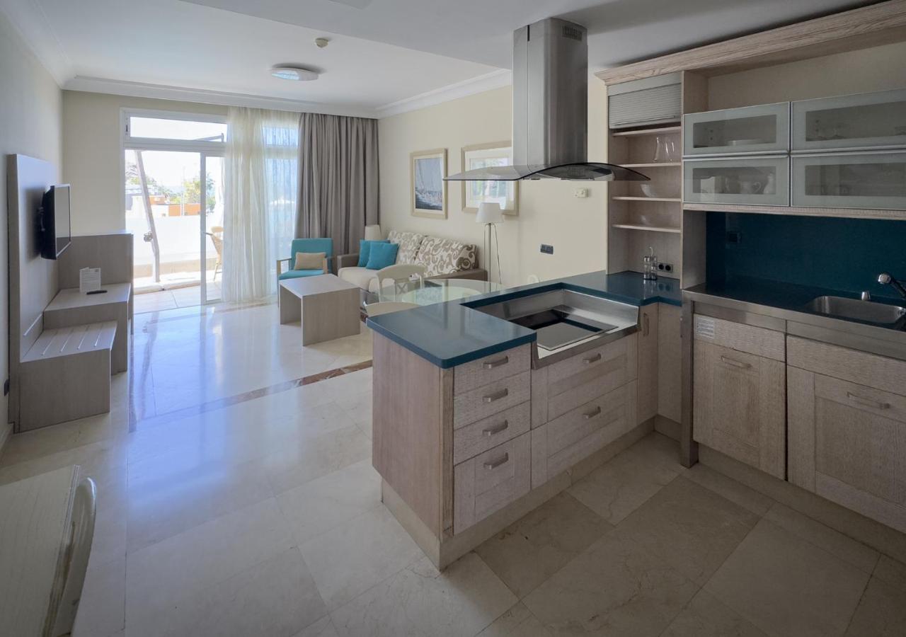 een keuken met blauwe aanrechtbladen en een woonkamer bij Holiday Club Playa Amadores in Amadores