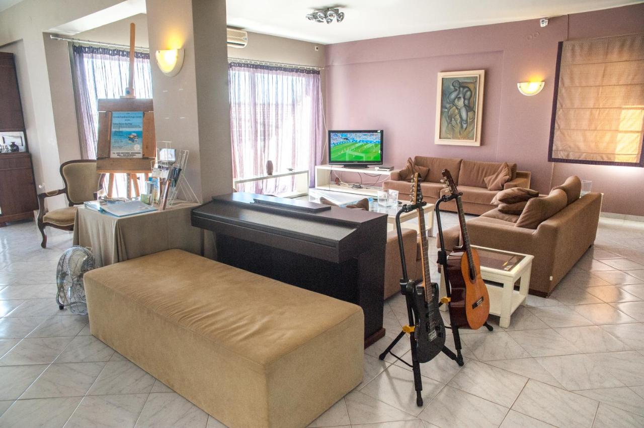 een woonkamer met een piano en een bank bij Mouikis Sun Village in Lakíthra