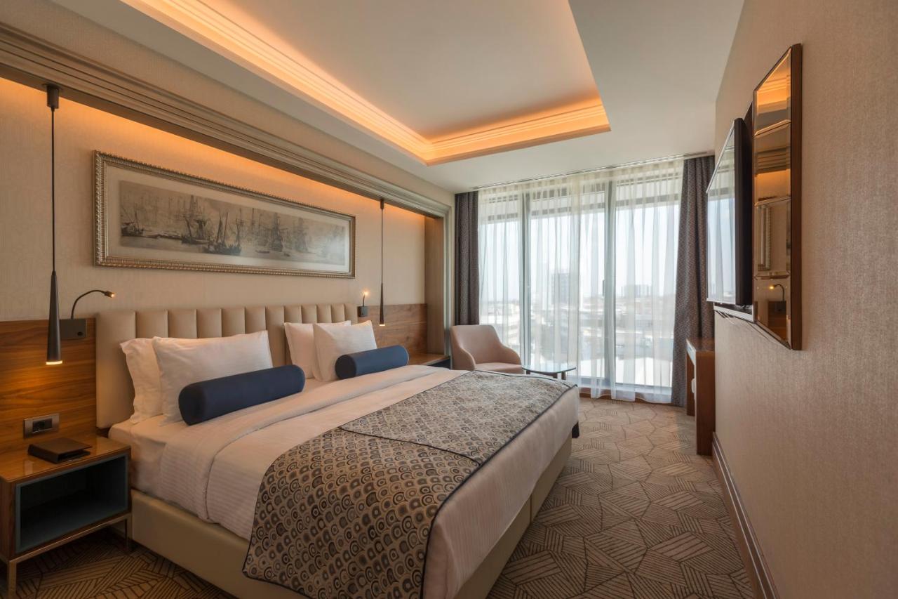 een hotelkamer met een bed en een groot raam bij Golden Tulip Istanbul Bayrampasa in Istanbul +60 foto's