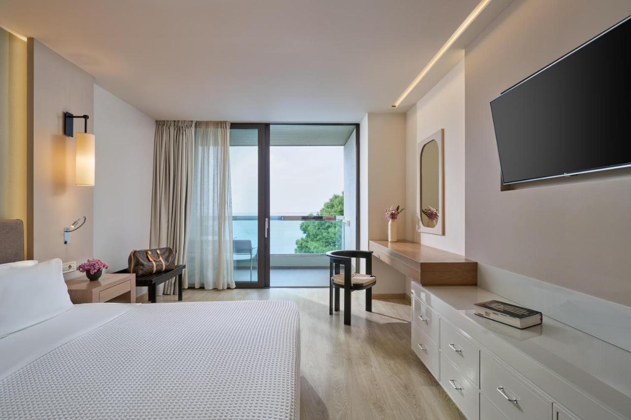 een hotelkamer met een bed en een flatscreen-tv bij White Rocks Hotel Kefalonia in Lassi