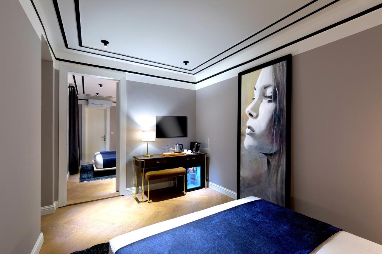 een slaapkamer met een groot schilderij van een vrouw aan de muur bij Walton Hotels Galata in Istanbul