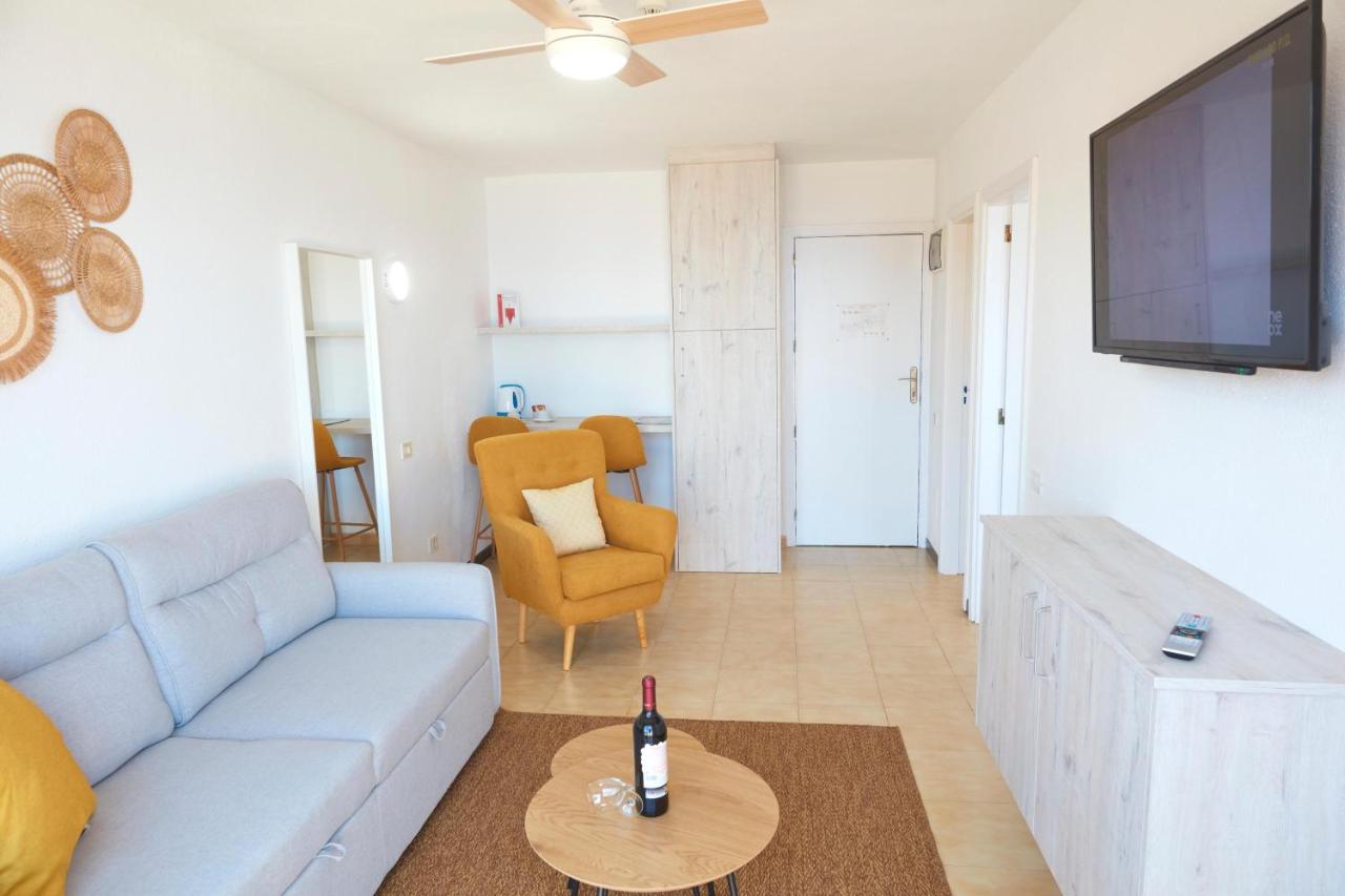 een woonkamer met een bank en een tv bij Hotel Chatur Palmera Mar in Amadores