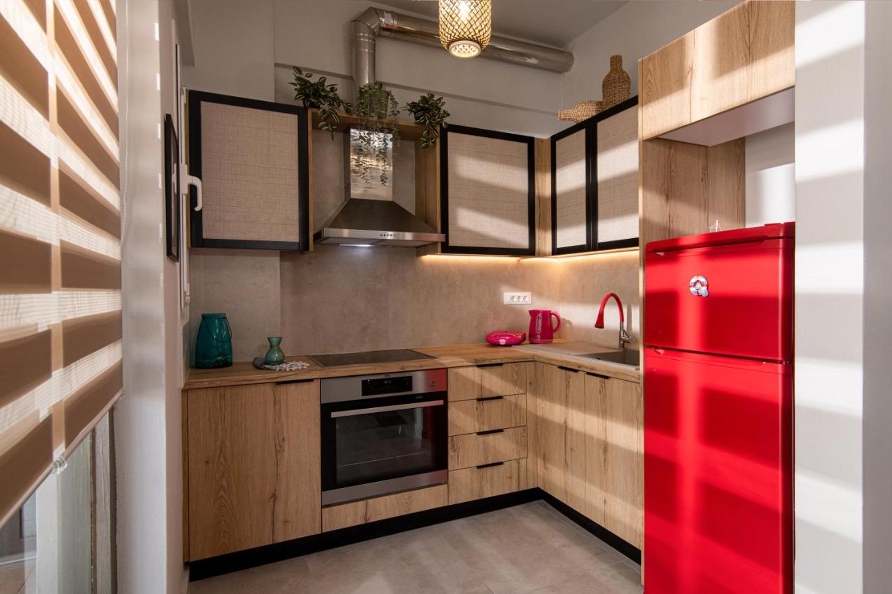 een keuken met een rode koelkast en houten kasten bij Natasha's Studio Apartment in Stalida