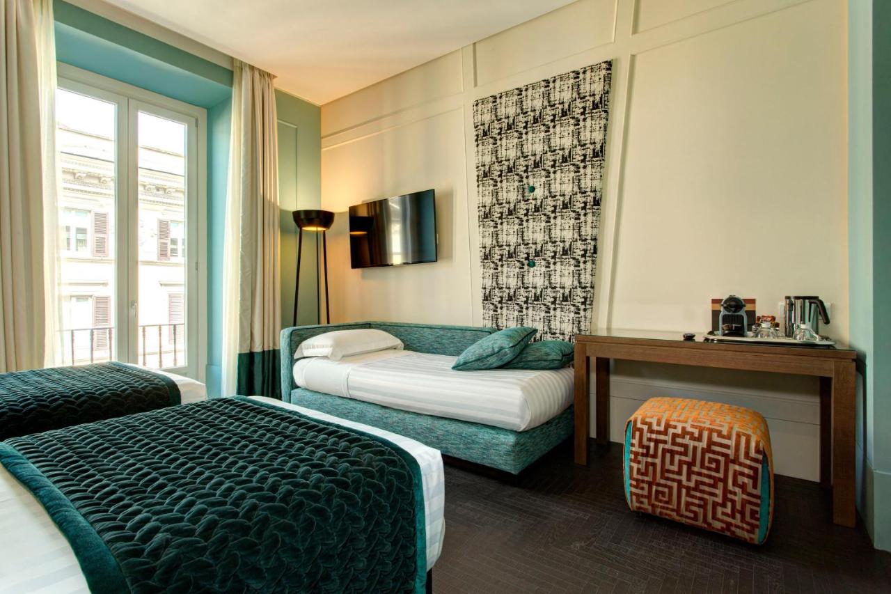 een hotelkamer met twee bedden en een raam bij Mascagni Luxury Rooms & Suites in Rome