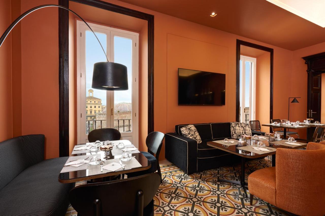 een restaurant met tafels en stoelen en een groot raam bij Mascagni Luxury Rooms & Suites in Rome