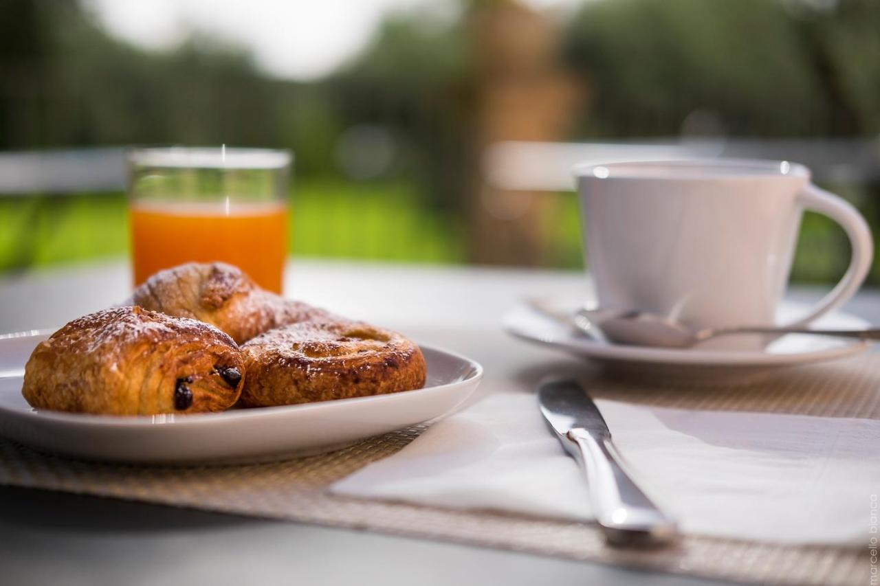 Twee gebakjes op een bord naast een glas sinaasappelsap. bij Masseria Degli Ulivi - Noto in Noto