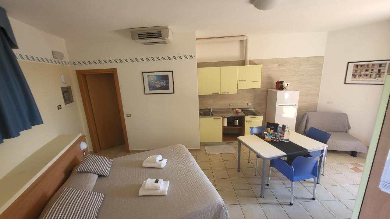een klein appartement met een tafel en een keuken bij Residence Rosemary in Brenzone sul Garda
