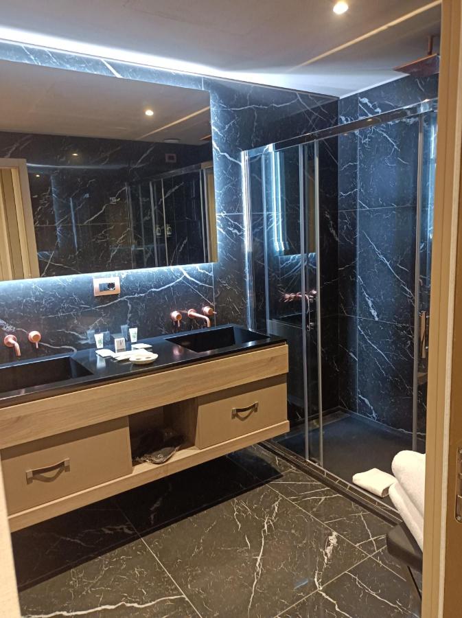 een badkamer met een wastafel en een glazen douche bij Miramare Suites in Sestri Levante