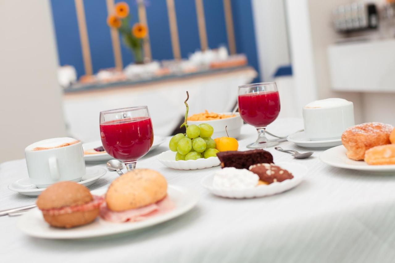een tafel vol met borden met eten en wijnglazen bij Hotel Star in Cesenatico