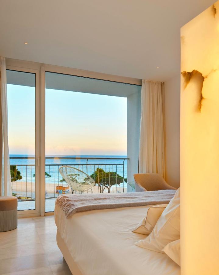 een slaapkamer met een bed en uitzicht op de oceaan bij Hotel Aromar in Platja  d'Aro