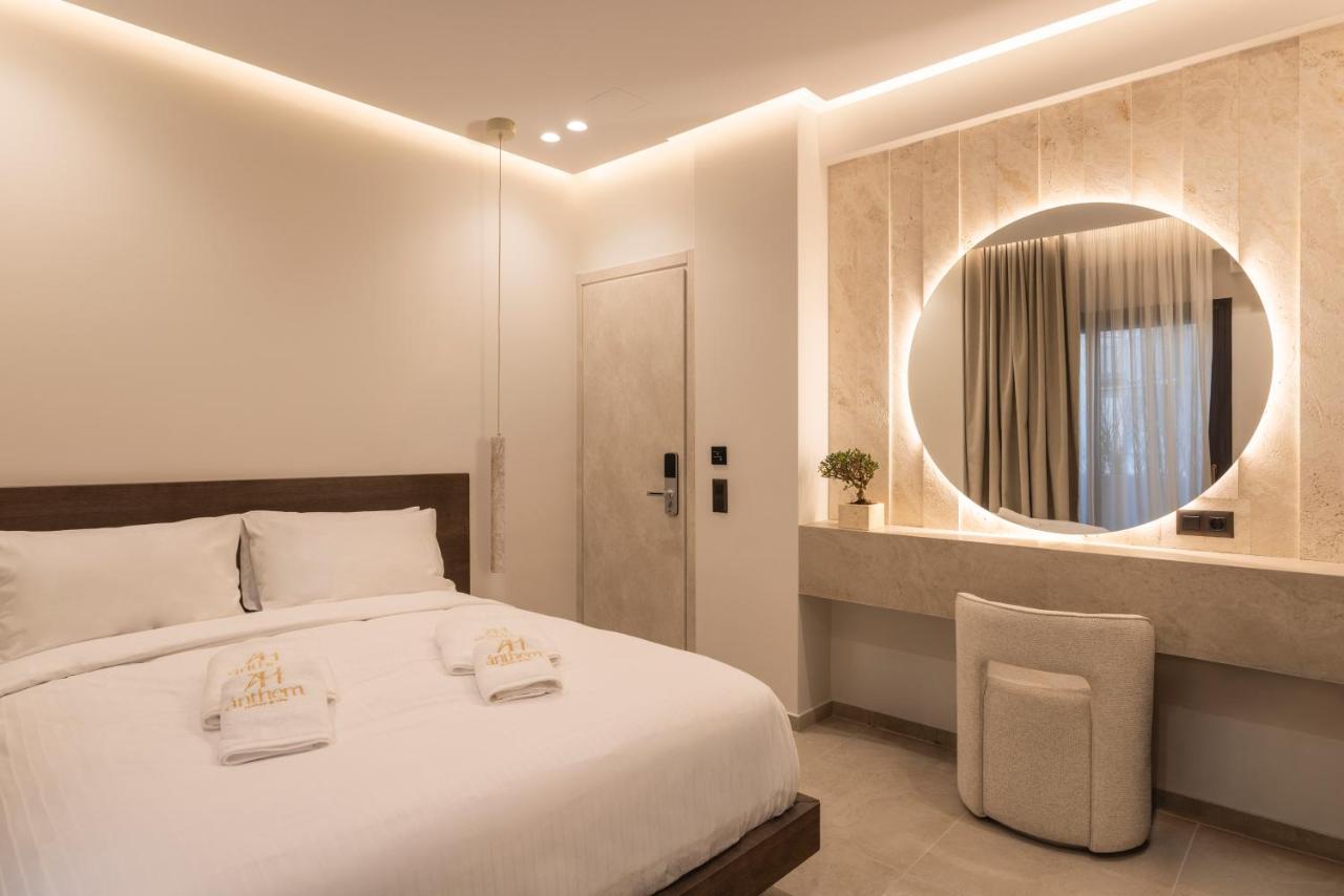 een slaapkamer met een groot bed en een spiegel bij Anthem Suites & Spa in Athene
