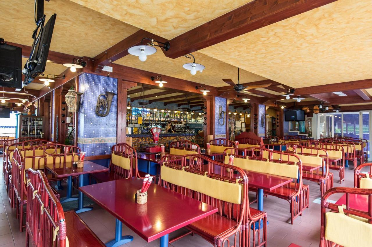 een restaurant met tafels en stoelen en een bar bij Hotel Christian in Lido di Jesolo