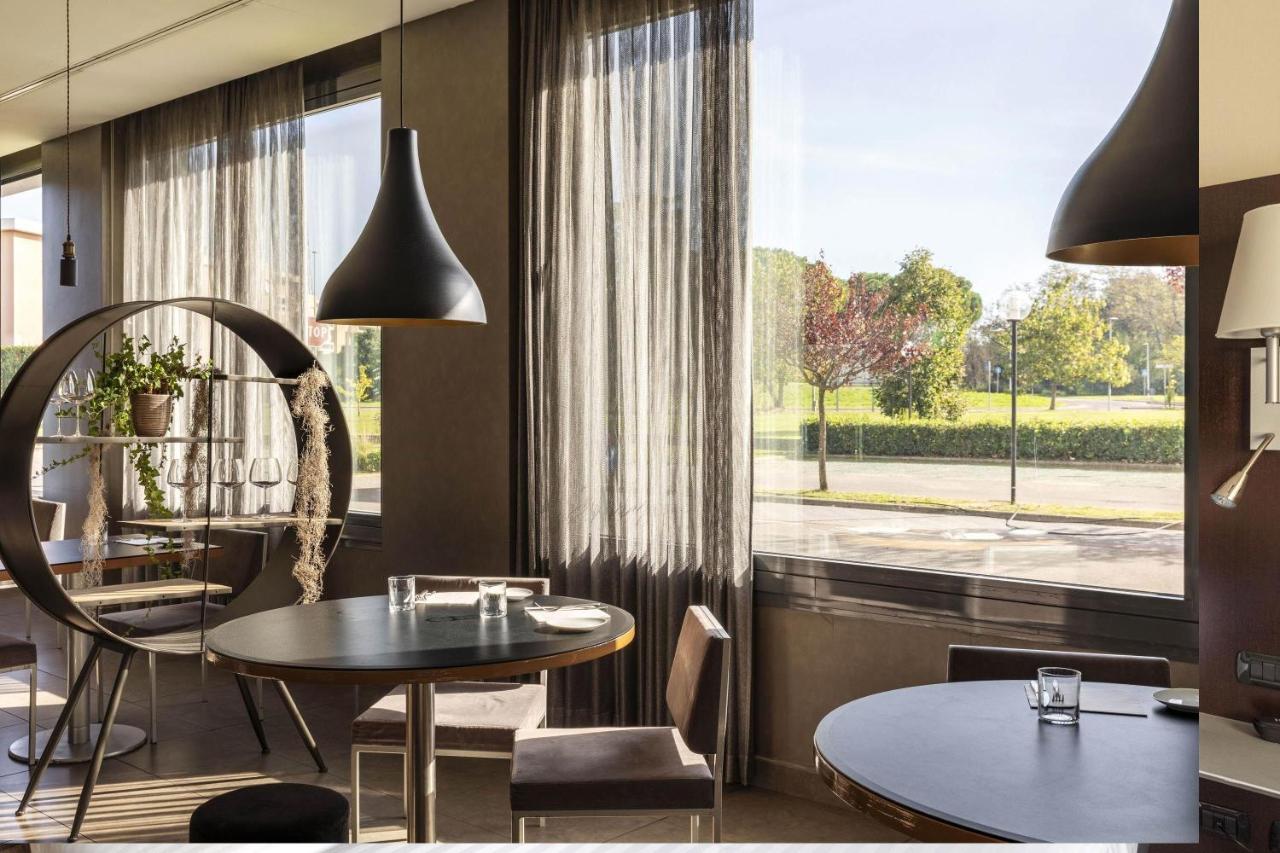 een eetkamer met een tafel en een raam bij B&B Hotel Arezzo in Arezzo