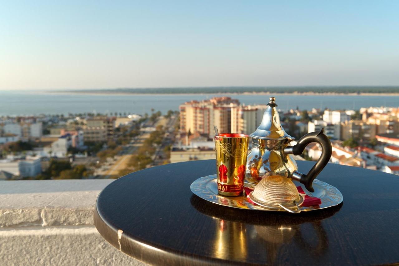 een tafel met twee kopjes en een theepot erop bij Hotel Guadalquivir in Sanlúcar de Barrameda