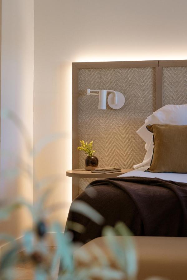 een slaapkamer met een bed met een hoofdbord en een plant bij Hotel Encinar de Sotogrande in Sotogrande