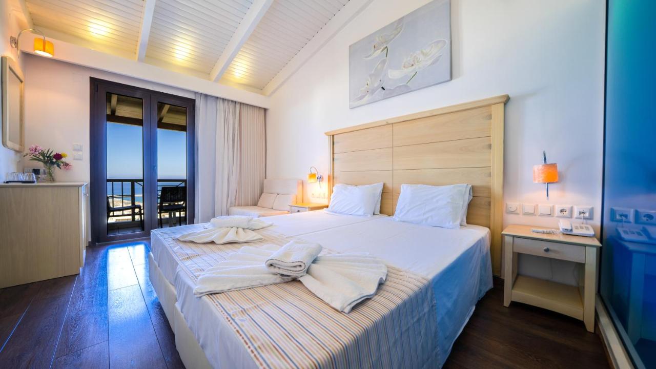 een slaapkamer met een groot bed en handdoeken erop bij Forest Park Hotel in Rethimnon