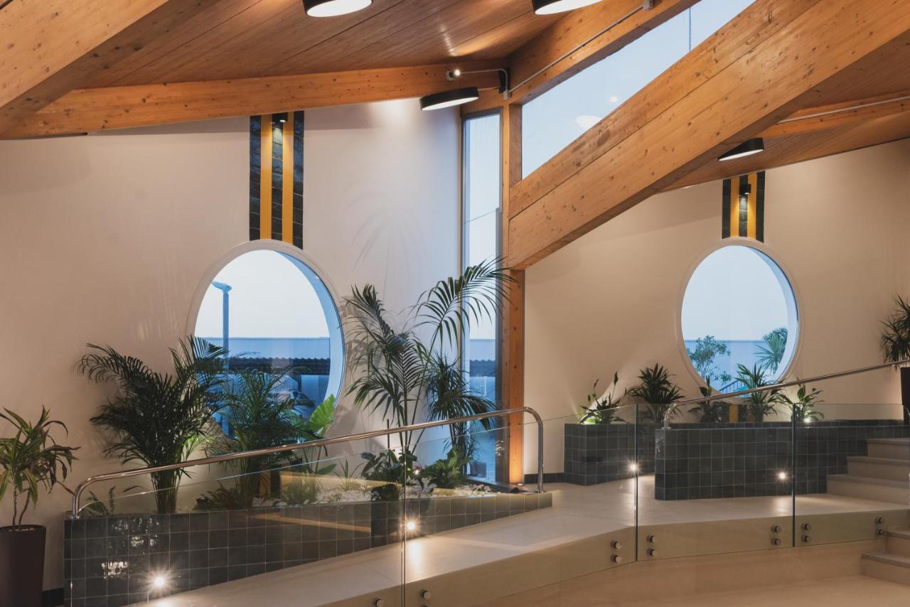 een lobby met grote ramen en potplanten bij Hotel Pradillo Conil in Conil de la Frontera