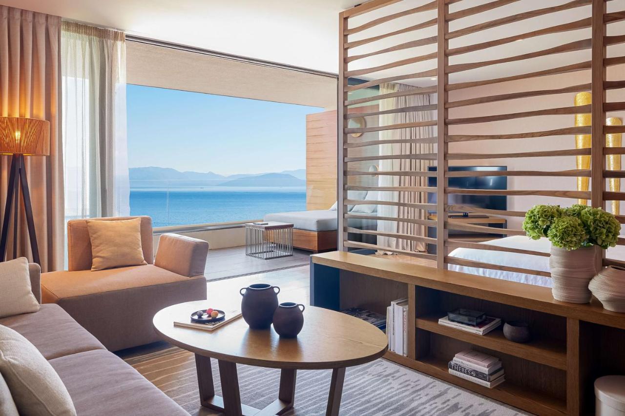 een woonkamer met een bank en een tafel bij Angsana Corfu Resort & Spa in Benitses