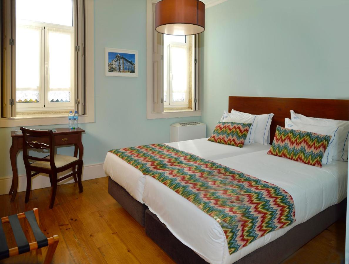 een slaapkamer met een bed, een bureau en een stoel bij Dukes Corner Guest House in Porto
