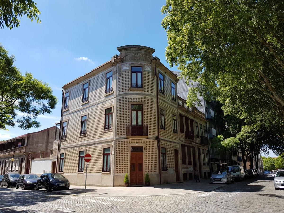 een oud bakstenen gebouw met auto's ervoor geparkeerd bij Dukes Corner Guest House in Porto